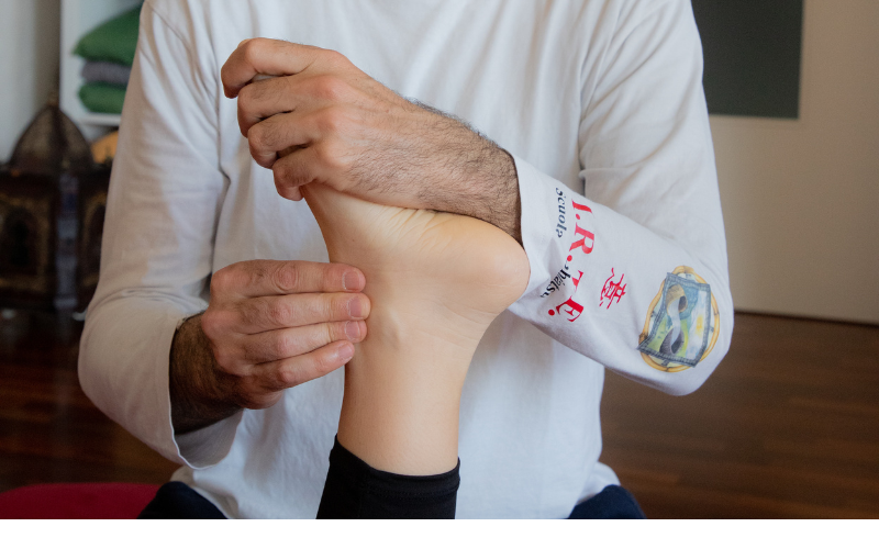 Operatore shiatsu esegue pressioni sul piede durante un trattamento