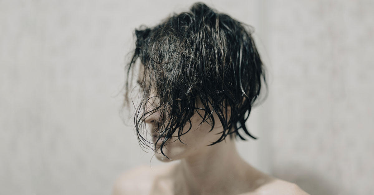Infelicità e stress - immagine di ragazza con capelli bagnati sul viso.