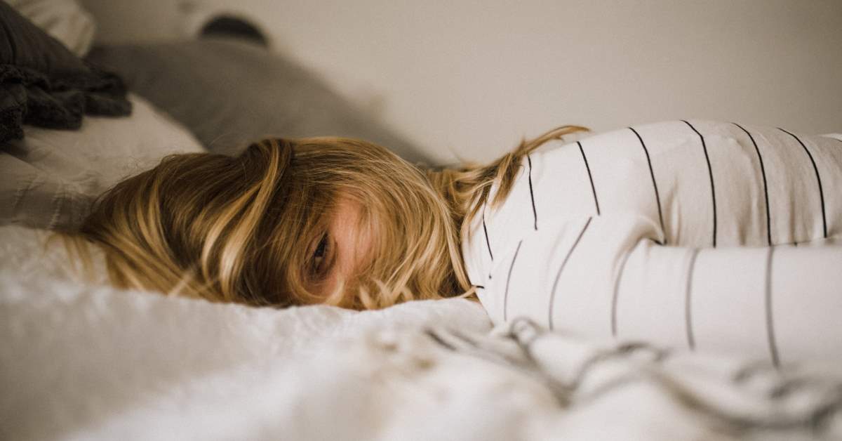 Ragazza triste distesa sul letto - Gestire lo stress con la Mindfulness
