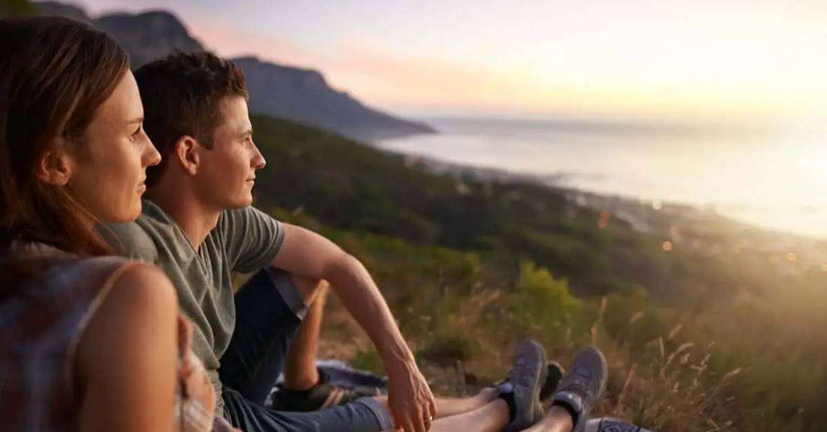 libri sulla Mindfulness - Immagine di coppia giovane che osserva il tramonto sul mare